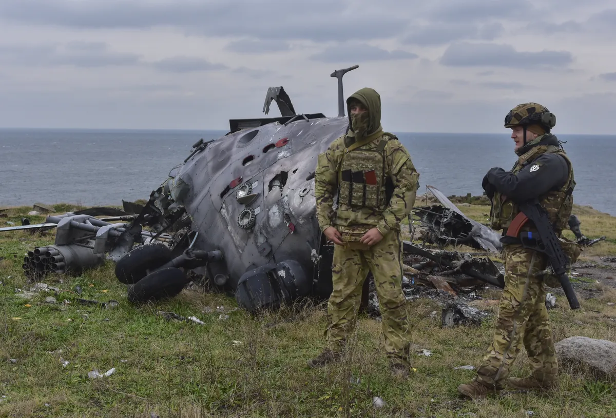 Украинские военные рядом с уничтоженным российским вертолетом