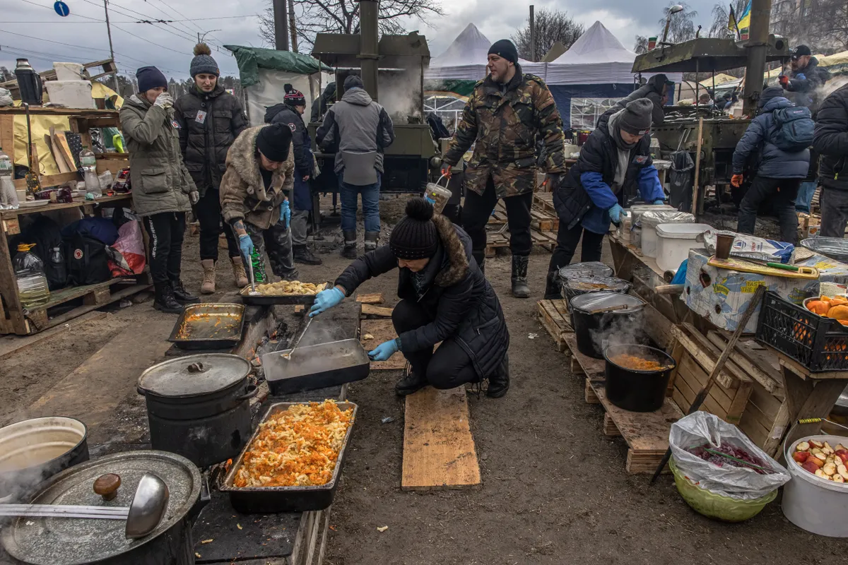 Местные жители готовят еду для солдат и других нуждающихся в лагере, развернутом рядом с блокпостом, Киев, 9 марта 2022 года