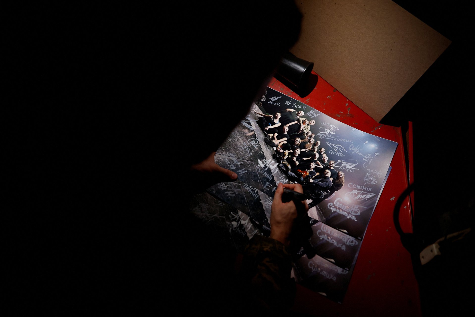 Иван Воинов подписывает групповое фото всех членов «Театра ветеранов» перед премьерой. Киев, 4 декабря 2025 года
