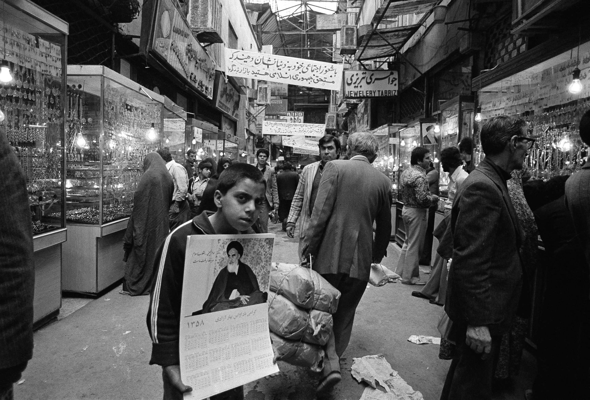 Иранский мальчик на Тегеранском базаре продает портреты аятоллы Хомейни после победы Исламской революции, июнь 1979 года