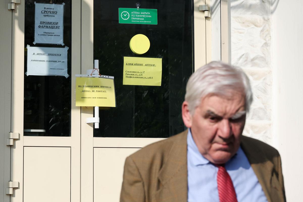 Мужчина стоит снаружи аптеки «Столички», которая не работает из-за хакерской атаки