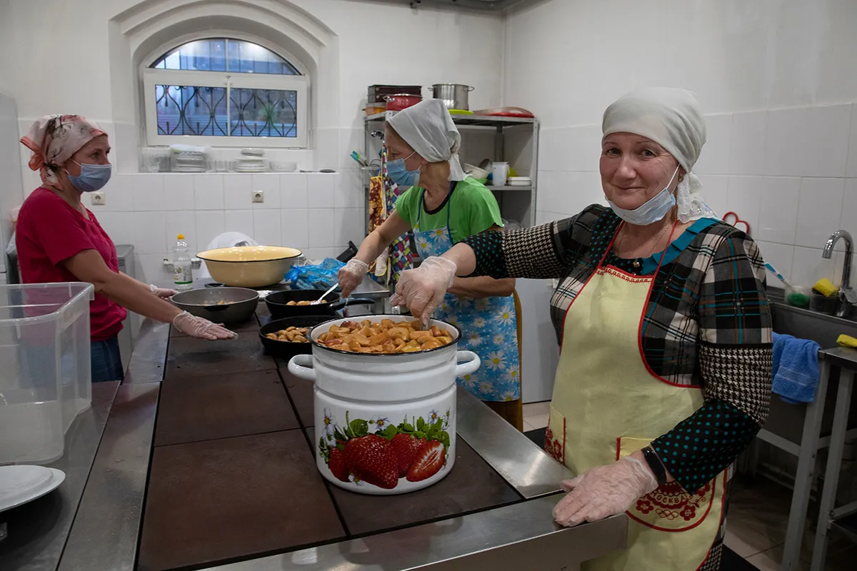 Волонтеры фонда «Хорошие люди» готовят еду в храме.