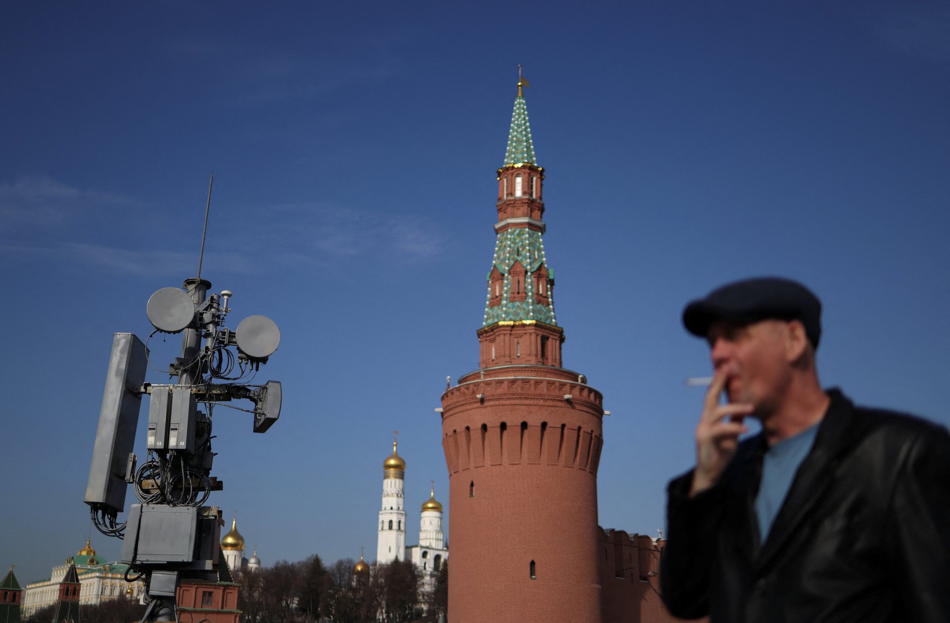 Мужчина курит у вышки сотовой связи на фоне Кремля. Митинг против блокировок интернета в Москве в эти выходные был запрещен в связи с коронавирусом