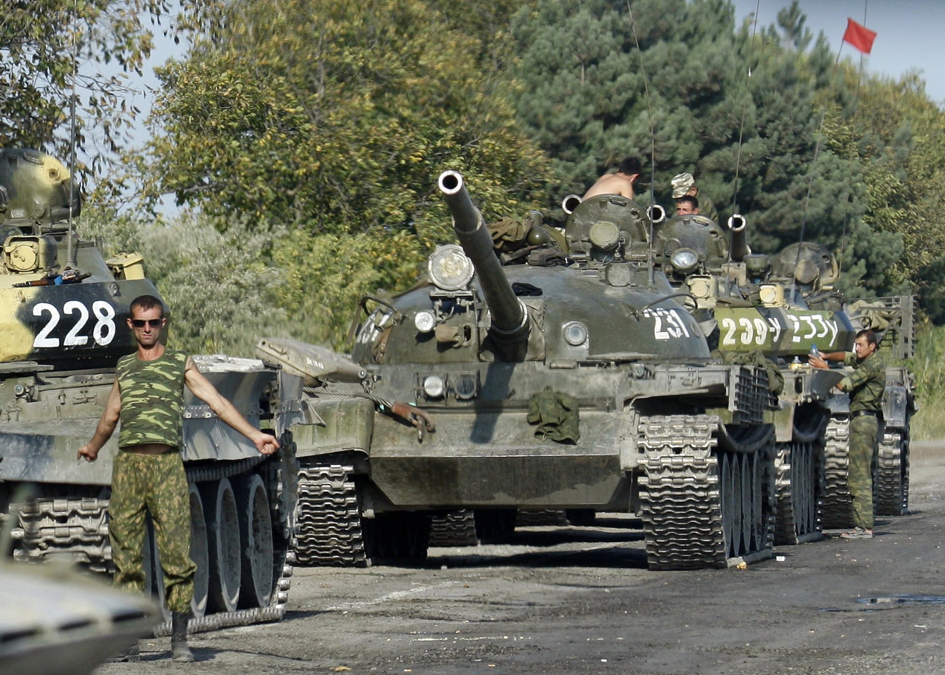 Российский военный разминается рядом с танком вблизи Гори
