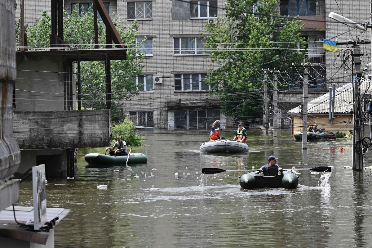 Волонтеры плывут на лодках во время эвакуации из затопленной зоны в Херсоне, 8 июня 2023 года