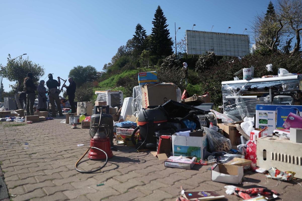 Сирийские военные стоят рядом с наворованными вещами местных жителей в Латакии