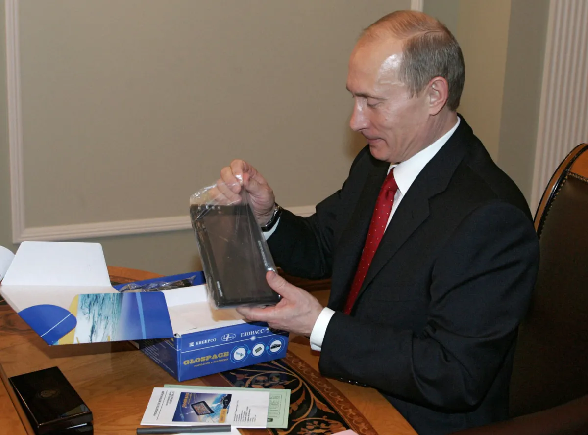 Власти любят играть в отечественные игрушки (на фото Владимир Путин с навигатором ГЛОНАСС), но предпочитают не замечать, что сделаны они из импортных деталей