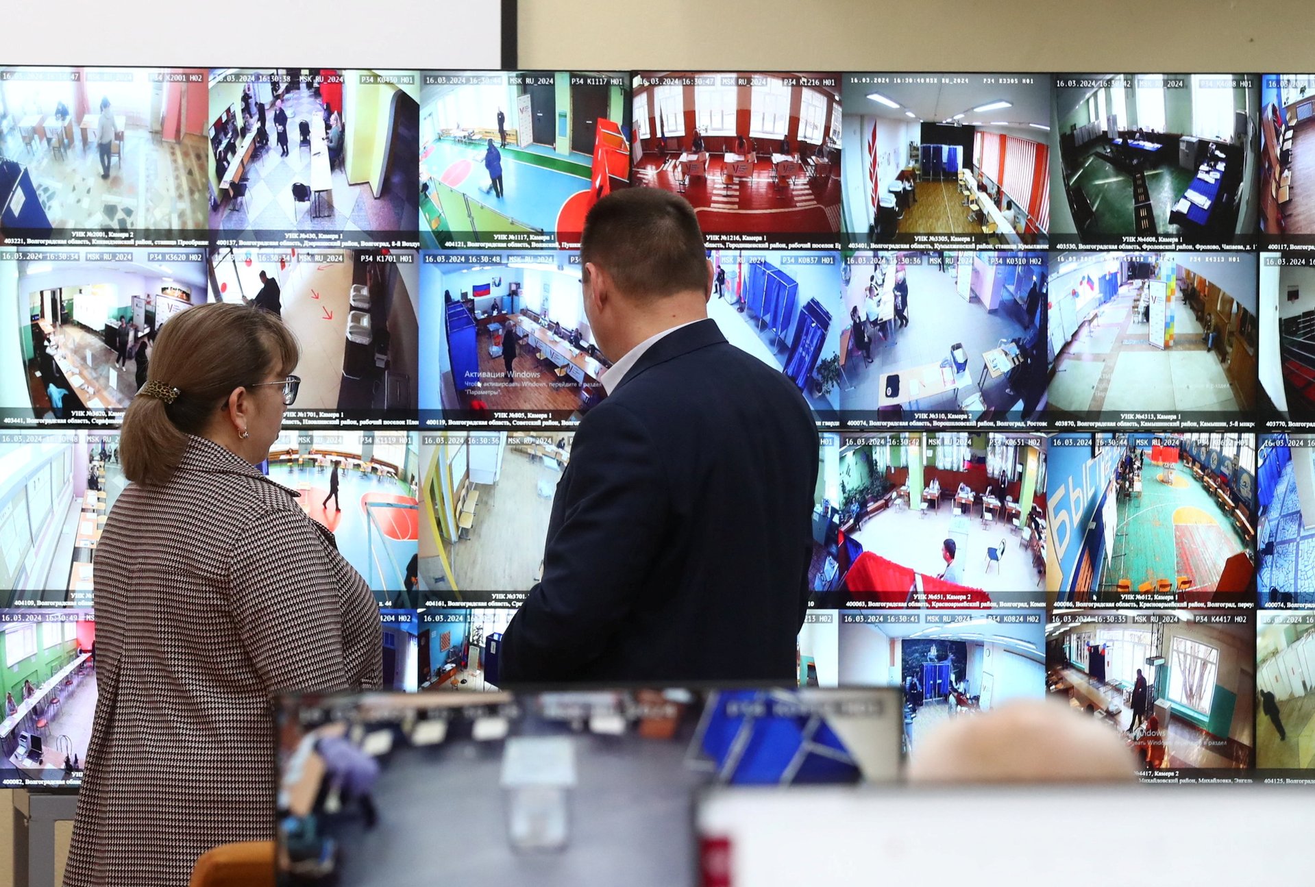 Наблюдатели следят за прямой трансляцией с избирательных участков в Волгограде, 16 марта 2024 года