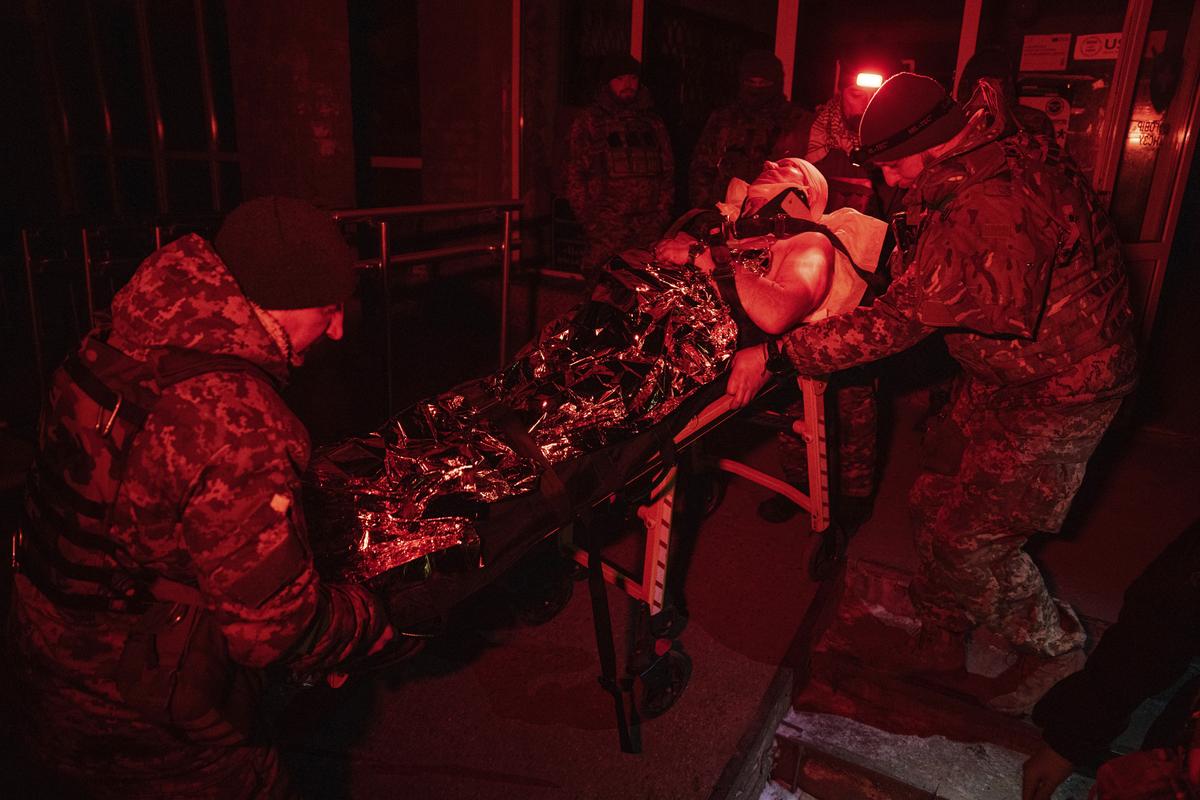 Украинские военные медики перевозят раненого бойца, эвакуированного с поля боя, в госпиталь в Донецкой области, 09.01.2023