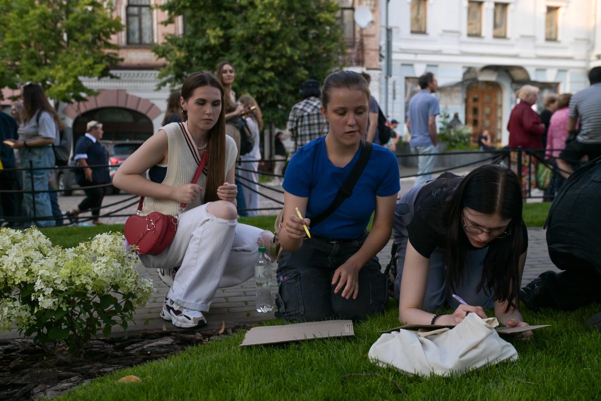 Участники митинга в Киеве рисуют плакаты, 22 июля