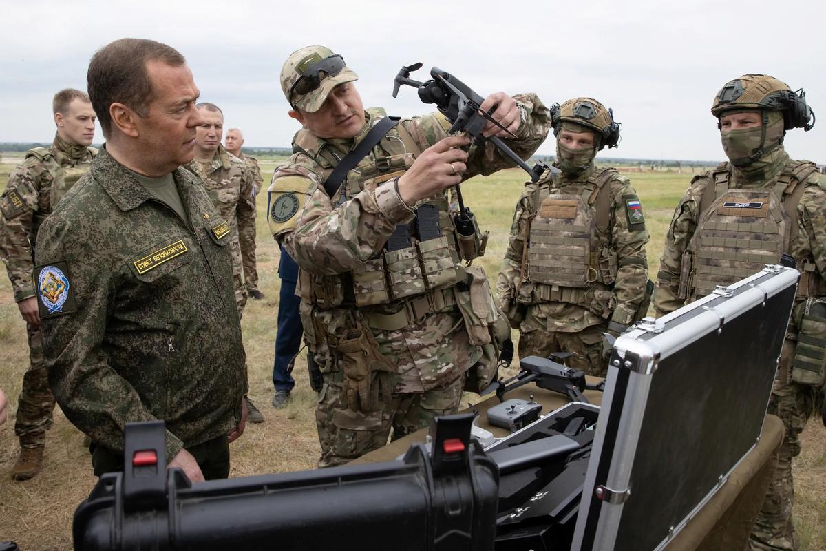Dmitry Medvedev, dressed in a military uniform, visits Prudboy surrounded by security guards and TV cameras on June 4, 2023