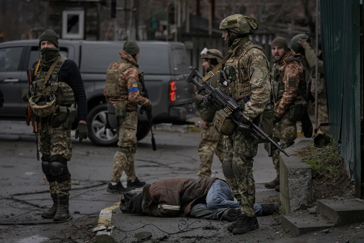 The Ukrainian military checking for booby traps on the bodies of the dead.