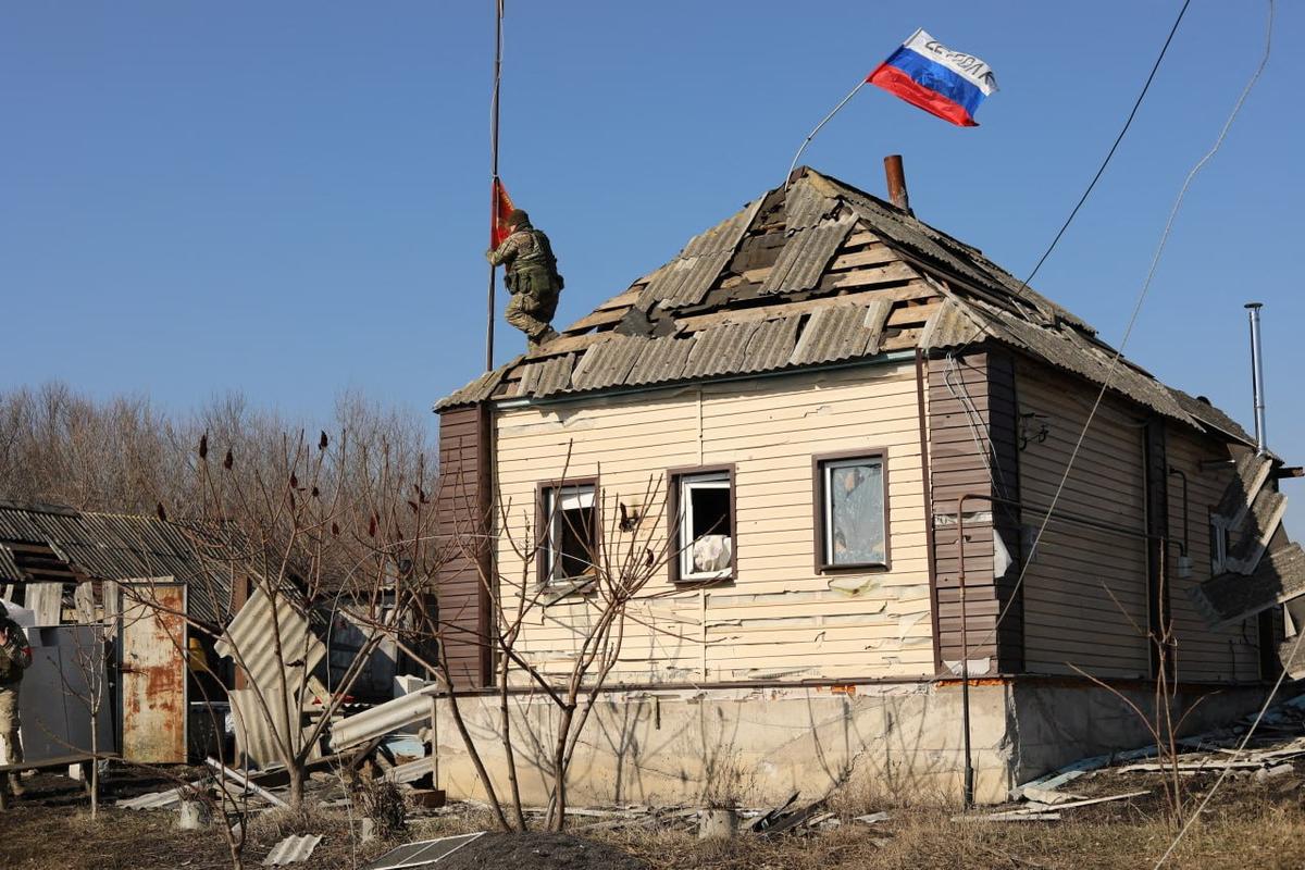 Российские военные устанавливают российский флаг в одном из районов Курской области, недавно отвоеванных у ВСУ
