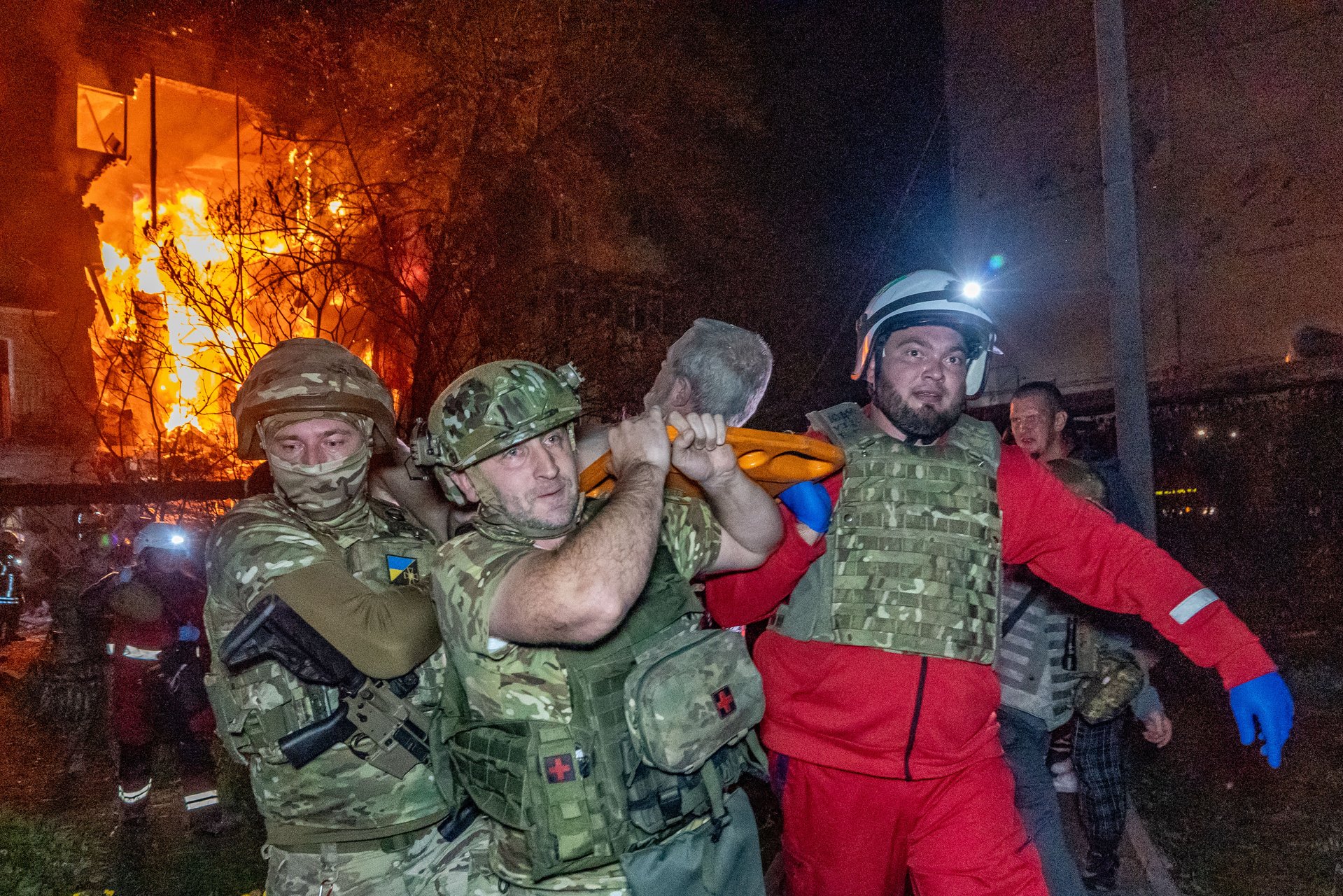 Спасатели эвакуируют раненого после удара по многоэтажке в Харькове. Четыре человека погибли, более 40 пострадали